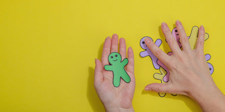 World mental health day. Female hands holding paper men figures with different emotions. Feedback rating, customer review, experience, satisfaction survey or assessment concept, flat lay, top viewの写真素材