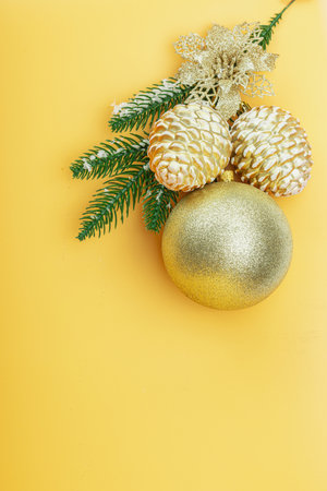 Traditional New Year composition. Festive decor, snowy Christmas tree branches, balls, golden flowers. Apricot color background, flat lay, top viewの写真素材