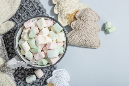 Hot cocoa or chocolate with marshmallows. Christmas traditional decor, New Year festive arrangement. The concept of coziness and good mood, gray background, top viewの写真素材