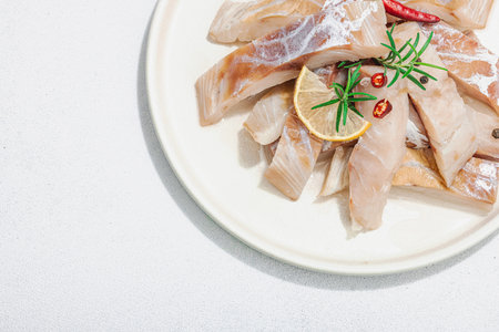Raw pollock (Pollachius virens) fillet. Fresh fish for healthy food lifestyle. Lemon, rosemary, sea...
