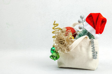 Christmas Sale concept on light stone background. Decorative fir tree, traditional New Year symbols. Zero waste shopping bag, festive baubles and decor, copy spaceの写真素材