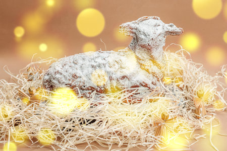 Christmas lamb cake with traditional New Year decor in hay. Baked sweet dessert with sugar icing. Festive background, winter holiday symbol. Dark stone concrete backgroundの写真素材