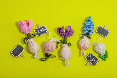 Spring planting and gardening concept. Handmade flowers with bulbs, crocheting. Hard light, dark...