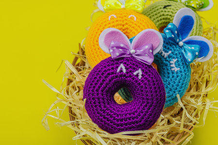 Handmade Easter concept. Crocheted donut bunnies with traditional decoration. Festive symbols,...