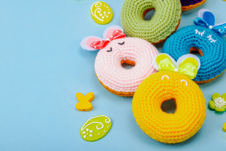Handmade Easter concept. Crocheted donut bunnies with traditional decoration. Festive symbols,...