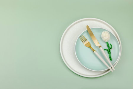 Minimalist spring table setting with crochet tulip. Traditional festive symbol, greeting card, flat lay. Pastel green background, top viewの写真素材