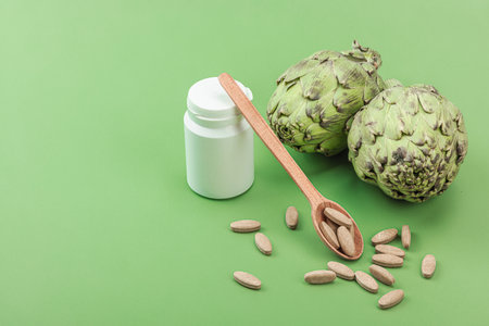 Dietary supplements Artichoke leaf extract capsules. Alternative medicine, herbal lifestyle, healthy self care. Savannah green trendy background, flat lay, copy spaceの写真素材