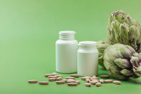 Dietary supplements Artichoke leaf extract capsules. Alternative medicine, herbal lifestyle, healthy self care. Savannah green trendy background, flat lay, copy spaceの写真素材