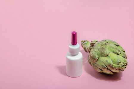 Dietary supplements Artichoke leaf extract capsules. Alternative medicine, beauty herbal lifestyle, healthy self care. Hard light, dark shadow, pink background, flat lay, copy spaceの写真素材
