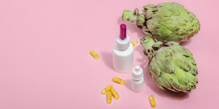 Dietary supplements Artichoke leaf extract capsules. Alternative medicine, beauty herbal lifestyle, healthy self care. Hard light, dark shadow, pink background, flat lay, banner formatの写真素材