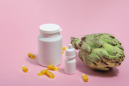 Dietary supplements Artichoke leaf extract capsules. Alternative medicine, beauty herbal lifestyle, healthy self care. Hard light, dark shadow, pink background, flat lay, close upの写真素材