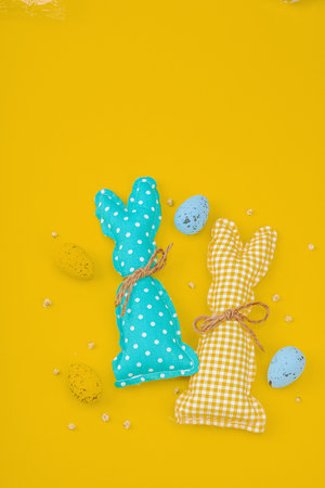 Handmade Easter concept. Sewn textile bunnies with traditional decoration. Festive symbols, greeting...