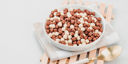 Vegan cereals in balls shape of cocoa and vanilla served with spoon. Full ready bowl to eat, healthy...