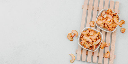 Dry pieces of apple in a bowls. Healthy food diet, vegan lifestyle, lose weight concept. White stone...