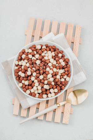 Vegan cereals in balls shape of cocoa and vanilla served with spoon. Full ready bowl to eat, healthy...