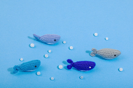 Summer crochet concept. Handmade fishes, marine style. Underwater animals, set of different sharks. Nautical blue background, flat lay, place for textの写真素材