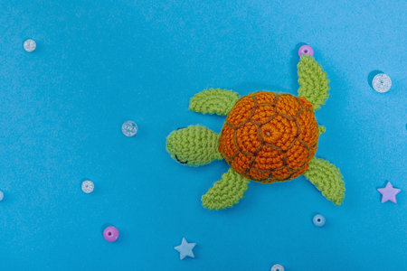 Summer crochet concept. Handmade turtle, marine style, underwater animal. Nautical blue background, flat lay, top viewの写真素材
