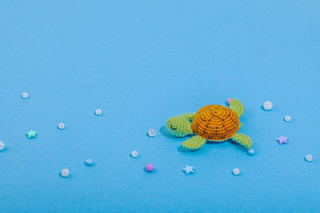 Summer crochet concept. Handmade turtle, marine style, underwater animal. Nautical blue background, flat lay, copy spaceの写真素材