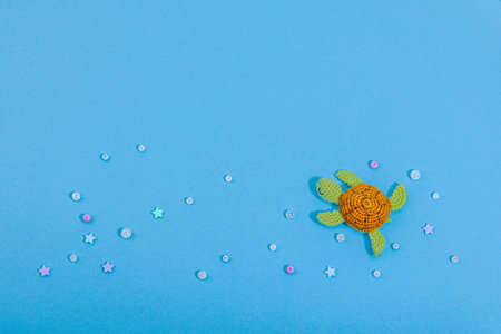 Summer crochet concept. Handmade turtle, marine style, underwater animal. Nautical blue background, flat lay, top viewの写真素材