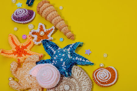 Summer crochet concept. Handmade coral reef, marine style, underwater animals. Nautical yellow background, flat lay, close upの写真素材