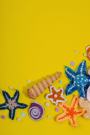 Summer crochet concept. Handmade coral reef, marine style, underwater animals. Nautical yellow background, flat lay, top viewの写真素材