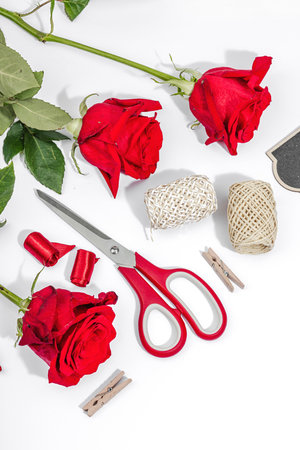 Gift design concept. Decor, special tools, ribbons, cardboard tags on a white background. Handmade, creative space, flat lay, top viewの写真素材