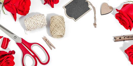 Gift design concept. Decor, special tools, ribbons, cardboard tags on a white background. Handmade, creative space, flat lay, banner formatの写真素材