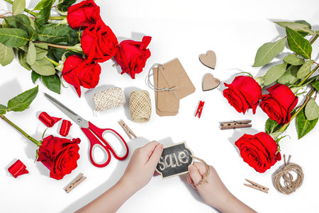 Gift design concept. The child is holding a sign in her hands. Handmade, creative space, flat lay, white background, top viewの写真素材