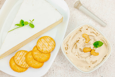 Set of assorted homemade vegan nuts cheese. Raw healthy sauce in a bowl, lactose free food. Bio organic product, plant based diet, alternative lifestyle. Light stone background, top viewの写真素材