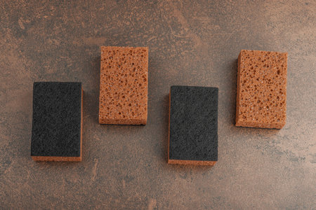 Set of sponges for washing dishes. Organic cleaning concept, coffee aroma. Zero waste style, warm brown stone background, flat lay, top viewの写真素材