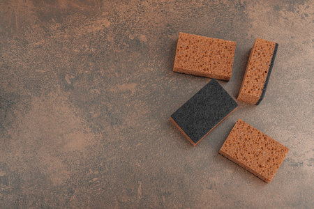 Set of sponges for washing dishes. Organic cleaning concept, coffee aroma. Zero waste style, warm brown stone background, flat lay, top viewの写真素材