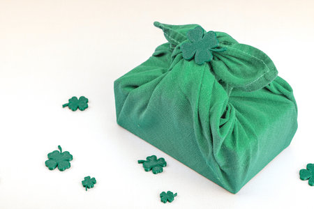 Handmade St. Patrick's Day gift concept. Furoshiki, traditional decorative symbols, crocheted hat,...