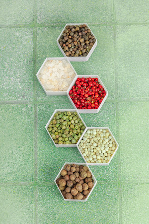 Set of fragrant spices and dried herbs. Healthy eating concept. Light green tile, flat lay, top view