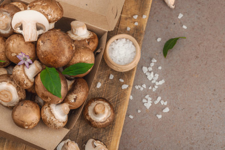 Fresh raw cremini mushrooms with spices and herbs. Healthy ingredient for cooking vegan food. Farm to table concept, flat lay, warm brown background, top viewの写真素材