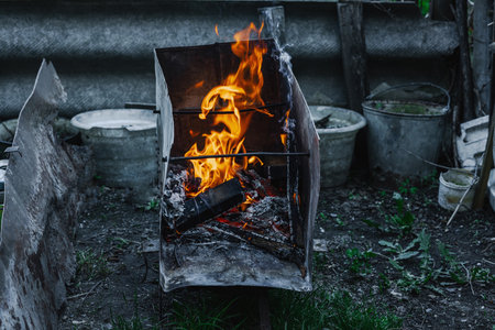 Open flame in a metal container used for heating or cooking in poor living conditions. Reflects urban poverty, displacement, and survival in crisis settingsの写真素材
