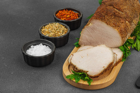 High-protein roasted pork loin served with flavor spices, styled for food photography. Suitable for keto and paleo diets, black stone background, copy spaceの写真素材