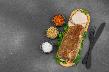 High-protein roasted pork loin served with flavor spices, styled for food photography. Suitable for keto and paleo diets, black stone background, top viewの写真素材