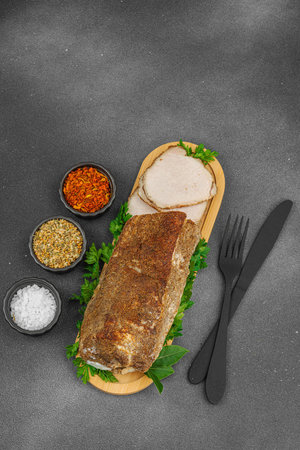 High-protein roasted pork loin served with flavor spices, styled for food photography. Suitable for keto and paleo diets, black stone background, top viewの写真素材