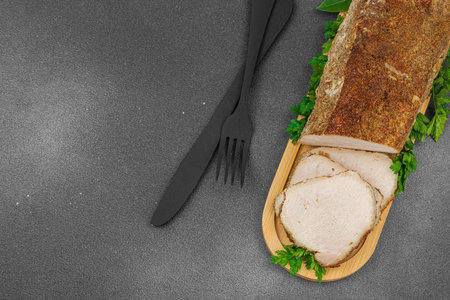 High-protein roasted pork loin served with flavor spices, styled for food photography. Suitable for keto and paleo diets, black stone background, top viewの写真素材