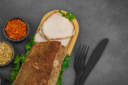 High-protein roasted pork loin served with flavor spices, styled for food photography. Suitable for keto and paleo diets, black stone background, top viewの写真素材