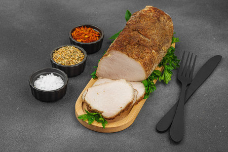 High-protein roasted pork loin served with flavor spices, styled for food photography. Suitable for keto and paleo diets, black stone background, copy spaceの写真素材