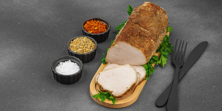 High-protein roasted pork loin served with flavor spices, styled for food photography. Suitable for keto and paleo diets, black stone background, banner formatの写真素材