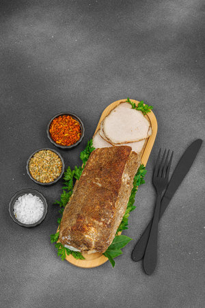 High-protein roasted pork loin served with flavor spices, styled for food photography. Suitable for keto and paleo diets, black stone background, top viewの写真素材