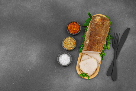 High-protein roasted pork loin served with flavor spices, styled for food photography. Suitable for keto and paleo diets, black stone background, top viewの写真素材