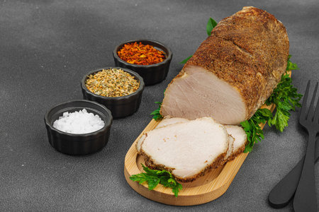High-protein roasted pork loin served with flavor spices, styled for food photography. Suitable for keto and paleo diets, black stone background, copy spaceの写真素材