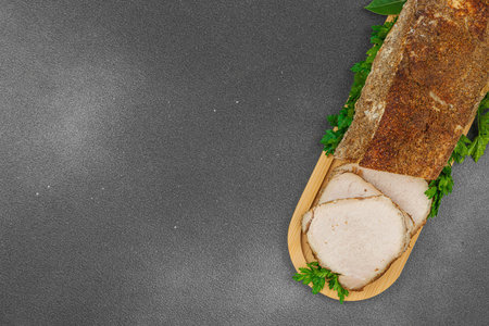 High-protein roasted pork loin served with flavor spices, styled for food photography. Suitable for keto and paleo diets, black stone background, top viewの写真素材