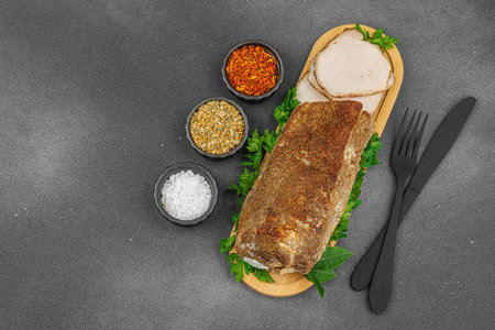 High-protein roasted pork loin served with flavor spices, styled for food photography. Suitable for keto and paleo diets, black stone background, top viewの写真素材