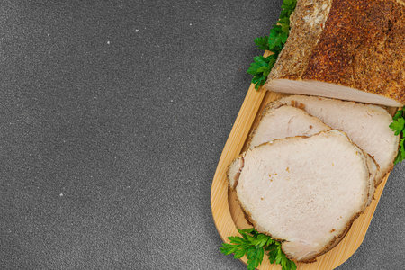 High-protein roasted pork loin served with flavor spices, styled for food photography. Suitable for keto and paleo diets, black stone background, top viewの写真素材