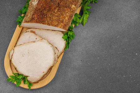 High-protein roasted pork loin served with flavor spices, styled for food photography. Suitable for keto and paleo diets, black stone background, top viewの写真素材