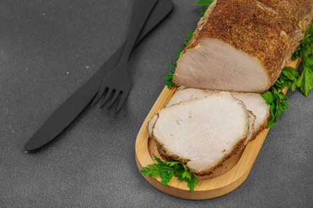 High-protein roasted pork loin served with flavor spices, styled for food photography. Suitable for keto and paleo diets, black stone background, copy spaceの写真素材
